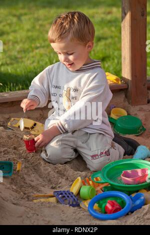 Kleiner Junge spielt in einer sandbox Stockfoto