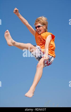 Ein Junge lachen und Springen, Timmendorf, Insel Poel, Mecklenburg-Vorpommern, Norddeutschland Stockfoto