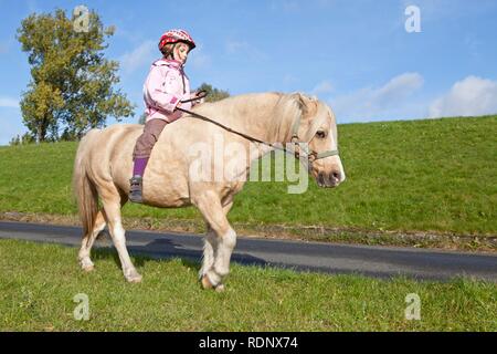 Junges Mädchen ein Pony reiten Stockfoto
