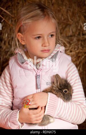 Junge Mädchen beim Kuscheln mit einem Kaninchen Stockfoto