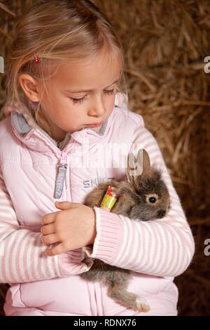 Junge Mädchen beim Kuscheln mit einem Kaninchen Stockfoto