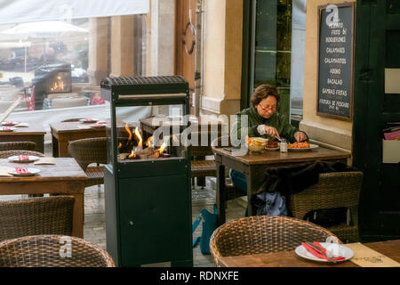 Malaga, Spanien - 10 April, 2018. Frau das Essen an den Tisch auf der Straße Restaurant in Malaga, Spanien Stockfoto