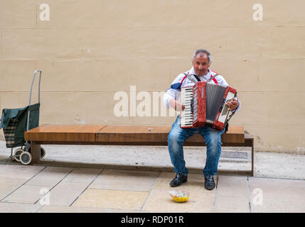 Malaga, Spanien - 10 April, 2018. Unbekannter Straßenmusiker Melodien spielen mit seinen alten Akkordeon in Malaga, Spanien Stockfoto