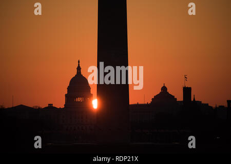 US Capitol Dome Washington Monument Sonnenaufgang Washington DC // WASHINGTON DC, Vereinigte Staaten - am frühen Morgen, wenn die Sonne zwischen dem US Capitol Dome und dem Washington Monument rauscht, vom Lincoln Memorial aus gesehen. Stockfoto