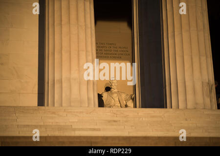 Lincoln Memorial Abraham Lincoln Statue Washington DC // WASHINGTON DC, Vereinigte Staaten - am frühen Morgen im Lincoln Memorial in Washington DC. Es befindet sich am westlichen Ende der National Mall und erinnert an den 16. Präsidenten der Vereinigten Staaten, Abraham Lincoln. Dieses Foto wurde rund um die Frühlingssonnenwende aufgenommen. Wenn die Sonne direkt im Osten aufgeht, scheint das Licht kurz direkt auf die massive Statue von Lincoln, die tief im Gebäude sitzt. Stockfoto