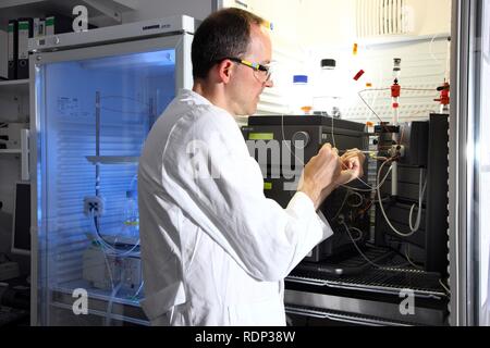 Biotechnologie Labor, FPLC-System für die Proteinaufreinigung, ein Wissenschaftler ist das Einfügen einer Probe in das Gerät, Zentrum für Stockfoto