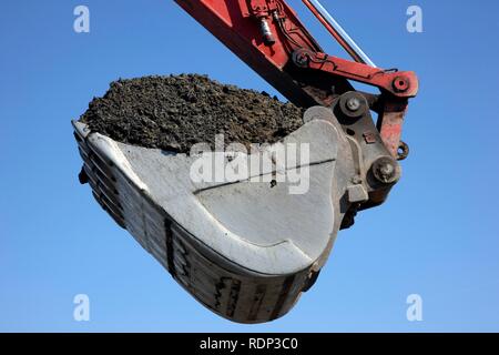 Bagger Schaufel, beladen mit Boden, Baustelle Stockfoto