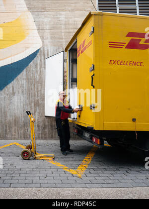 INCA, PALMA DE MALLORCA, SPANIEN - 8. Mai 2018: Seitenansicht des Senior DHL Briefträger die Post Pakete von der gelben Lkw auf der im Zentrum der Stadt Inca auf Mallorca Stockfoto