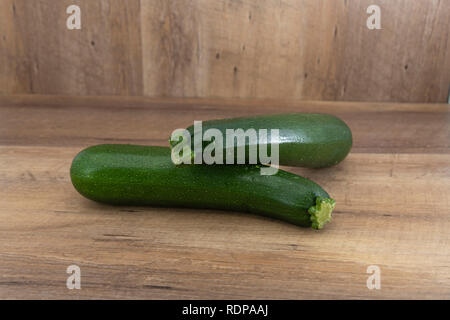 Zwei Zucchini oder Zucchini auf natürlichen Holz- Hintergrund mit markieren und Schatten getrennt. Stockfoto