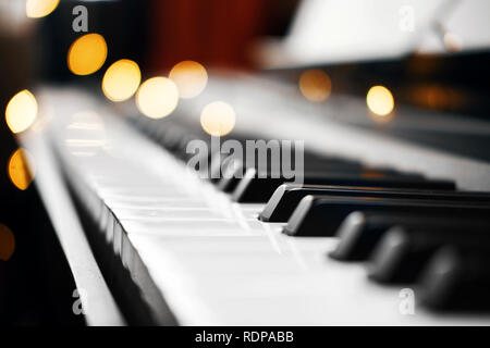 Piano keys mit schönen gelben Lichter Bokeh im Hintergrund, Piano keys mit der Weihnachtsbeleuchtung Stockfoto