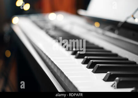 Piano keys mit schönen gelben Lichter Bokeh im Hintergrund, Piano keys mit der Weihnachtsbeleuchtung Stockfoto