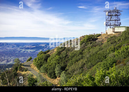 Straße und Antenne Tower auf der Spitze des Mt Diablo; San Francisco Bay und San Mateo Bridge im Hintergrund; Mt Diablo State Park, Contra Costa County, San F Stockfoto