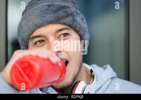 Junge latin man Trinkwasser runner Space copyspace Kopieren winter Joggen laufen sport training Fitness im Freien Stockfoto
