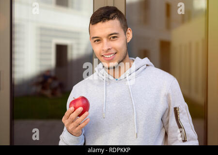 Junge latin Mann essen Apfel Obst runner Winter laufen sport training Fitness im Freien Stockfoto