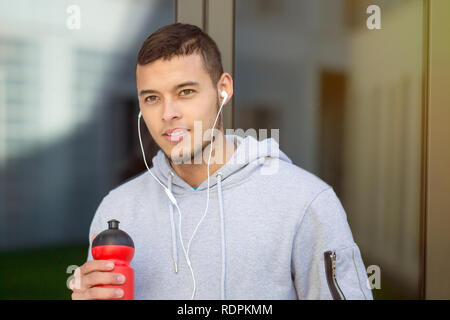 Trinkwasser junger Mann Läufer laufen Suchen denken Jogging Sport Training Fitness im Freien Stockfoto