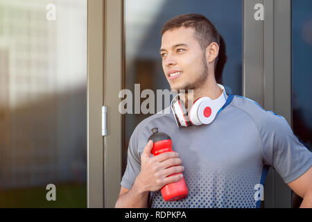 Junge latin Mann Wasser Flasche suchen denken Tag träumen Runner copyspace Kopie Raum laufen sport training Fitness im Freien Stockfoto