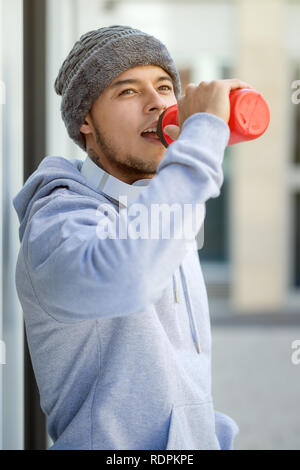 Sport Ausbildung junger Latin man Trinkwasser suchen denken Hochformat runner Outdoor Stockfoto