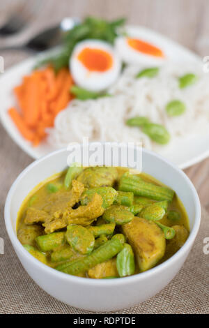 Thai Food spicy Schweinefleisch und Gemüse Parkia speciosa Curry mit Kokosmilch und Thai Reis Mehl Nudeln Stockfoto