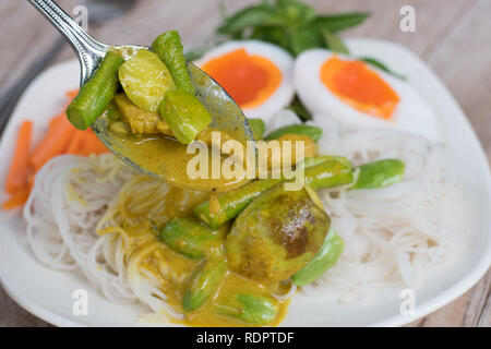 Thai Food spicy Schweinefleisch und Gemüse Parkia speciosa Curry mit Kokosmilch und Thai Reis Mehl Nudeln Stockfoto