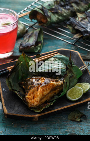 Gegrillte stingray Flügel oder sambal Stingray in Blatt mit Kalk und würzigen Dressing, malaysische Küche Stockfoto