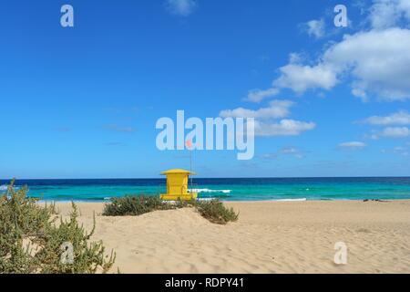 Gelbe post Rettungsschwimmer am Strand von Corralejo, Fuerteventura, Spanien. Golden Sands, bewölkt blauer Himmel und türkisfarbenem Meer. Stockfoto