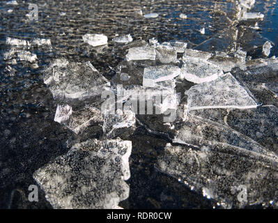 Kleine Klumpen aus Eis auf einem Dünn gefrorenem Wasser Oberfläche Stockfoto