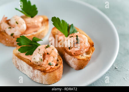 Bruschetta Sandwiches mit Garnelen, cremige Sauce und Petersilie. Stockfoto