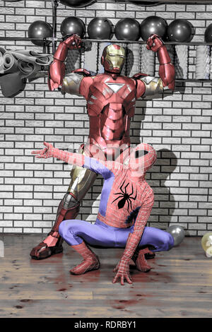 Animateure Iron Man und Spider-man im Fitnessraum an eine Firmenfeier Stockfoto