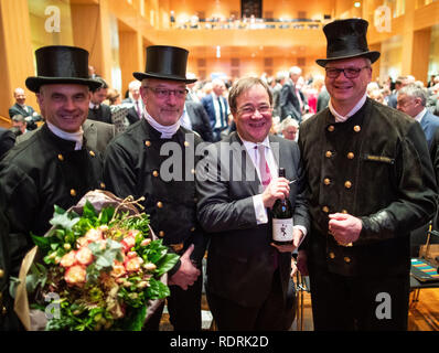 19. Januar 2019, Nordrhein-Westfalen, Düsseldorf: NRW-Ministerpräsident Armin Laschet (CDU, 2. von rechts) erhält eine Flasche Wein vom Schornsteinfeger auf dem Neujahrsempfang der CDU auf das Neue Jahr. Foto: Marcel Kusch/dpa Stockfoto