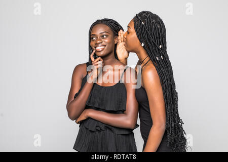 Porträt von zwei glückliche junge afrikanische Frauen teilen Geheimnisse isoliert Stockfoto