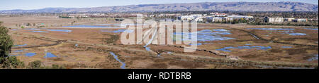 Luftaufnahme von Sumpfland in Don Edwards Wildlife Refuge, Büro Gebäude im Hintergrund; San Francisco Bay Area, Fremont, Kalifornien Stockfoto