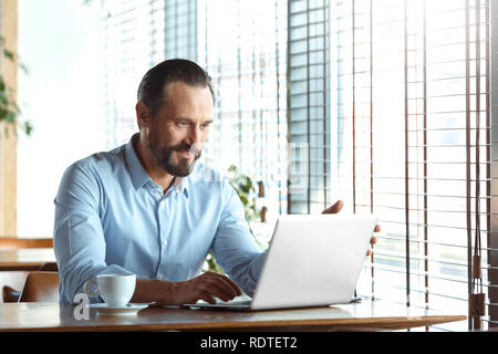 Business Lifestyle. Händler im Cafe sitzen und Kaffee surfen Laptop freudigen Lächeln Stockfoto