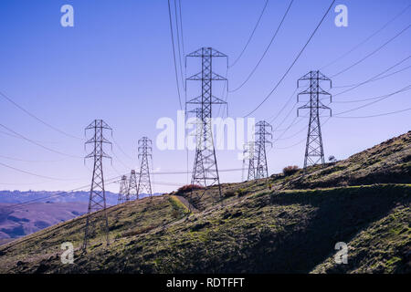 Hohe Spannung Strom Türme auf einem blauen Himmel Hintergrund, San Francisco Bay Area, Kalifornien Stockfoto