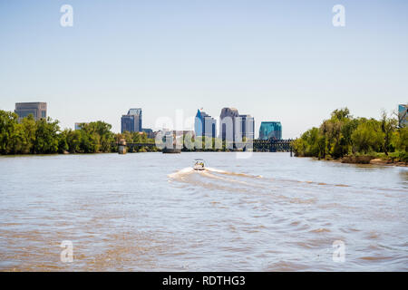 Boot Kreuzfahrt auf dem schlammigen Wasser suchen von Sacramento River; Downtown Skyline der Stadt im Hintergrund; Kalifornien Stockfoto