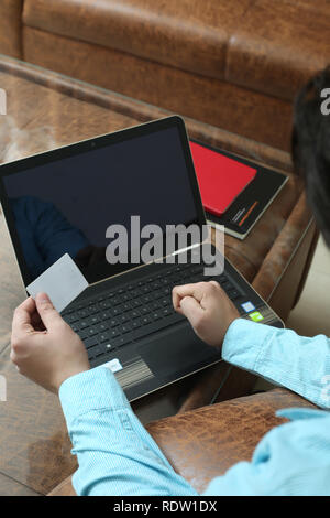 Der Mensch ist die Karte in der Hand mit Laptop. Stockfoto