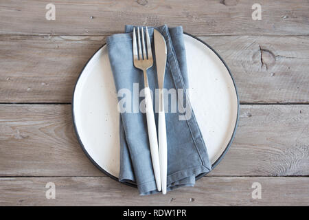 Natürliche Tisch-plain Keramikplatte, , Serviette, Besteck auf Holztisch. Umweltfreundliche Konzept, im nordischen Stil. Stockfoto
