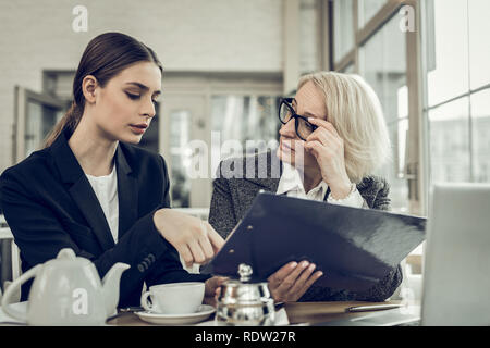 Junge unerfahrene Teilnehmer, Fragen zu Ihrer weiblichen Boss Stockfoto