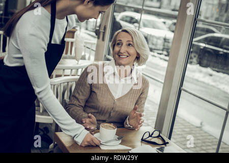 Elegante Frau Gefühl dankbar, während Ihr Kaffee immer auf Cafeteria Stockfoto