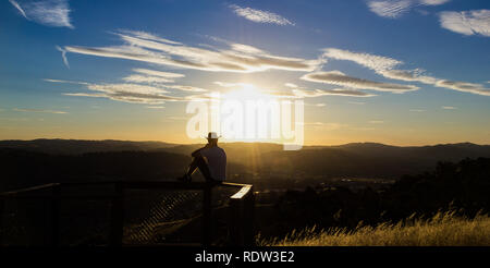 Junge Mann ist mit Blick auf den Sonnenuntergang, Albury, New South Wales, Australien Stockfoto