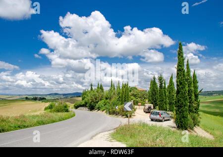 Toskana Landschaft mit Straßen, Zypressen, antiken Villen und blauer Himmel mit einigen Wolken Stockfoto