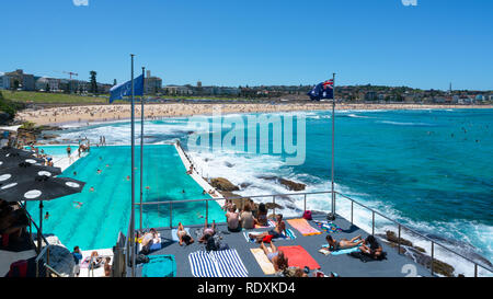 24. Dezember 2018, Bondi Sydney Australien: Schwimmbad und Australische Flagge vor Bondi beach Panorama mit Menschen beim Sonnenbaden auf einer sonnigen Summe Stockfoto