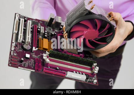 Kühler und Mainboard in der Menschen Hände close-up auf hellem Hintergrund isoliert Stockfoto