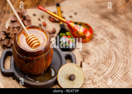 Honig Stick in ein Faß mit Honig und frisch gestrichenen Russischen Holzlöffel. Rustikal. Close-up. Stockfoto