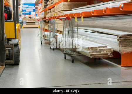 Bau Warenkorb im Gebäude zu speichern. Karren mit Boards geladen. shop von Baustoffen. Regale mit Platten, Holz und Baumaterial. geladen. c Stockfoto