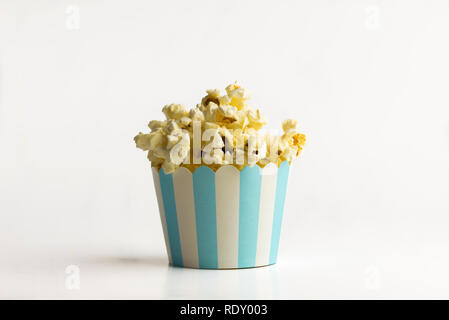 Popcorn in eine kleine Papierfach auf weißem Hintergrund - ein Konzept Stockfoto