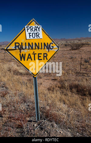 Beten Sie für fließendes Wasser eine humorvolle Zeichen zu Dürre im Südwesten von New Mexico, im Zeitalter des globalen Klimawandels Stockfoto