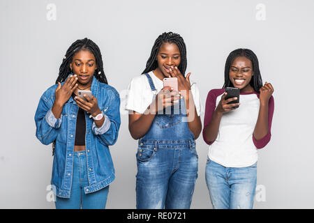 Portrait von afrikanischen Frauen überrascht, Nachricht lesen Handys auf weißem Hintergrund Stockfoto