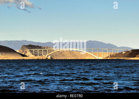 Kroatien, Dalmatinische Küste, Jadranovo Dorf, die Brücke, die das Festland mit der Insel Krk. Brücke von Krk ist eine 1430 m lange Bogenbrücke aus Stahlbeton Anschluss der kroatischen Insel Krk mit dem Festland und über eine Million Fahrzeuge pro Jahr. Der längere der beiden Bögen der Brücke ist der zweitlängste Beton arch in der Welt und unter den längsten Bögen der Bau. Die Brücke wurde abgeschlossen, und im Juli 1980 eröffnet und ursprünglich genannt Titow die meisten (" Tito's Bridge") zu Ehren des jugoslawischen Präsidenten Josip Broz Tito, der zwei Monate vorher gestorben. Stockfoto