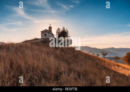 Kleine Kapelle in Rhodope Berg in der Nähe von Borovo Dorf, Herbst Sonnenuntergang Foto aus Bulgarien Stockfoto