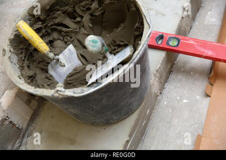 Ein Kunststoff Eimer mit Zement Klebstoff bereit zum Verkleben von keramischen Fliesen verwendet werden. Stockfoto